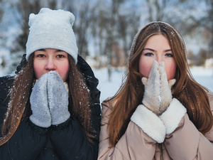 Zwei Frauen bibbern in der Kälte. 