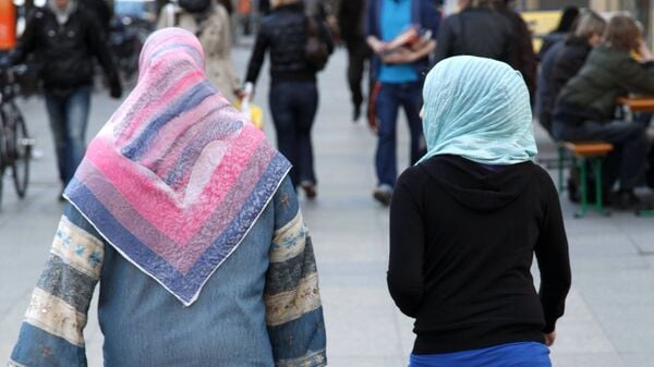 Zwei Frauen mit Kopftuch sind von hinten zu sehen (Symbolbild)