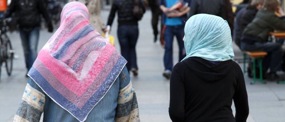 Zwei Frauen mit Kopftuch sind von hinten zu sehen (Symbolbild)