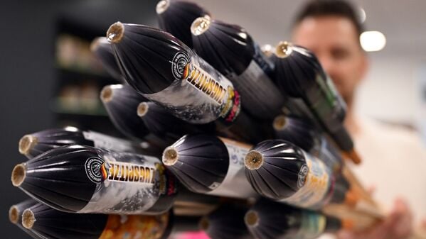 Ein Mitarbeiter hält im Showroom der Feuerwerksfirma Weco Silvesterraketen.