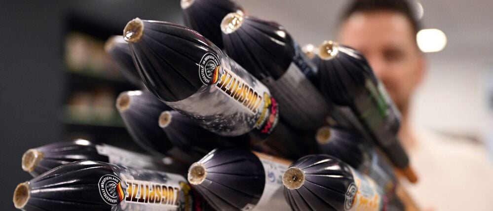 Ein Mitarbeiter hält im Showroom der Feuerwerksfirma Weco Silvesterraketen.