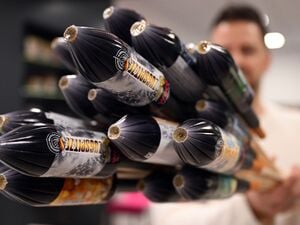 Ein Mitarbeiter hält im Showroom der Feuerwerksfirma Weco Silvesterraketen.