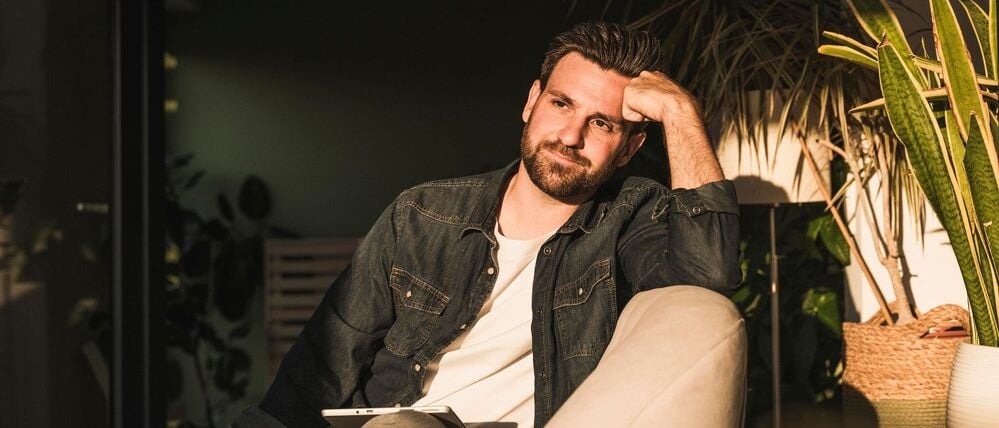 Ein Mann sitzt allein auf einer Couch 