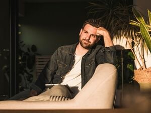 Ein Mann sitzt allein auf einer Couch 