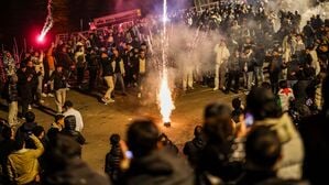 Männer zünden an Silvester in der Böllerbotszone in der Düsseldorfer Altstadt Feuerwerk.