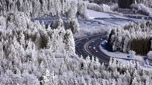 Autos fahren auf der in der winterlichen Landschaft gelegenen Autobahn 7 bei Oy-Mittelberg in Bayern.