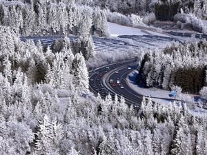 Autos fahren auf der in der winterlichen Landschaft gelegenen Autobahn 7 bei Oy-Mittelberg in Bayern.