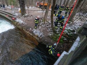 Mitarbeiter der Berufsfeuerwehr bauen in Anwesenheit von Polizeibeamten die diversen Einbauten und Vorrichtungen für eine künstliche Welle am Eisbach wieder ab.