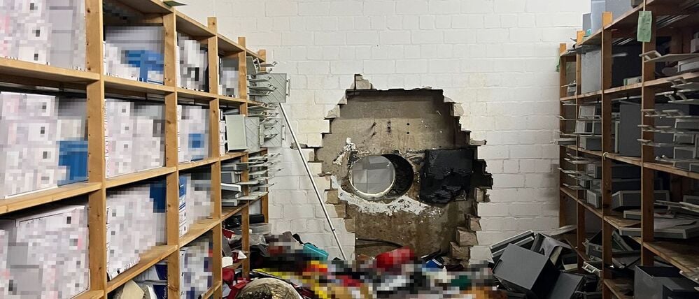 Ein großes Loch ist in der Wand des Tresorraums einer Sparkasse zu sehen. Einbrecher haben sich mithilfe eines großen Bohrers Zugang zum Tresorraum verschafft. 