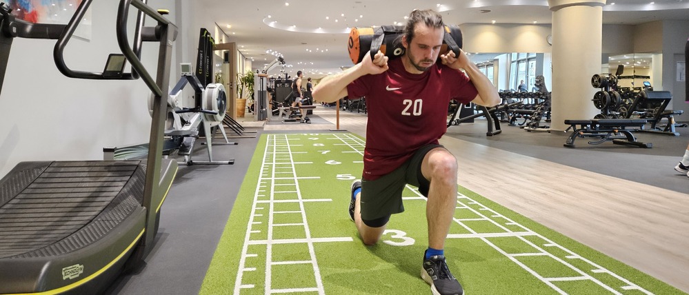 Sportredakteur Julian Graeber leidet bei den Lunges – Ausfallschritten mit einem Sandsack auf den Schultern. 