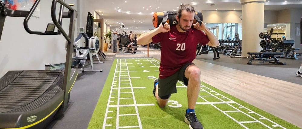 Sportredakteur Julian Graeber leidet bei den Lunges – Ausfallschritten mit einem Sandsack auf den Schultern. 