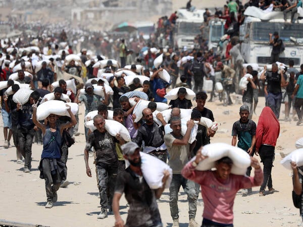 250728 -- BEIT LAHIA, July 28, 2025 -- Palestinians carry bags of flour after the humanitarian aid entered Gaza through a border crossing, in Beit Lahia, northern Gaza Strip, on July 27, 2025. The Israeli military on Sunday announced a daily 10-hour humanitarian pause in its operations in parts of the Gaza Strip, along with the opening of secure routes for aid delivery, amid growing international pressure over the deepening hunger crisis there. The Israel Defense Forces IDF said in a statement that it would halt military activity in areas including Al-Mawasi, Deir al-Balah and Gaza City, from 10:00 a.m. to 8:00 p.m. local time 0700-1700 GMT every day until further notice. Designated secure routes will be open daily from 6:00 a. PUBLICATIONxNOTxINxCHN