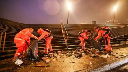 01.01.2026, Hamburg: Mitarbeiter der Stadtreinigung Hamburg räumen am Neujahrsmorgen abgebrannte Feuerwerkskörper und anderen Müll von der Jan-Fedder-Promenade vor dem Museumsschiff Cap San Diego an den Landungsbrücken im Hafen. Foto: Christian Charisius/dpa +++ dpa-Bildfunk +++