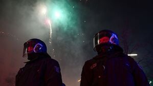 Feuerwerk explodiert während der Silvesternacht in Neukölln hinter Polizei in Berlin.