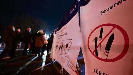 Berlin: Passanten stehen an der Kontrolle eines Eingangs in die Pyrotechnikverbotszone am Alexanderplatz während der Silvesternacht.