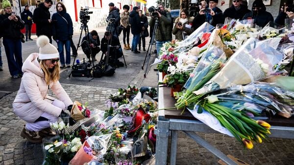 Menschen erweisen den Opfern der Silvesterfeier mit Blumen die letzte Ehre in der Nähe der Bar „Le Constellation“. 
