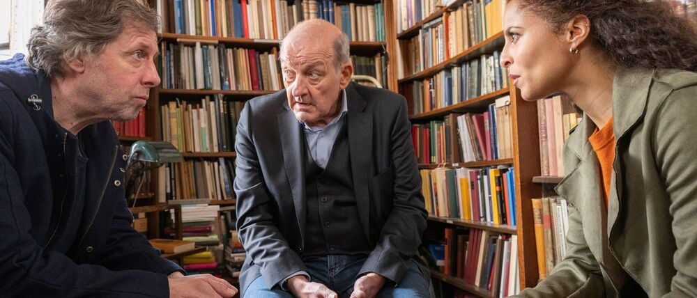 Teambesprechung zwischen Bücherregalen bei „Wilsberg“. 