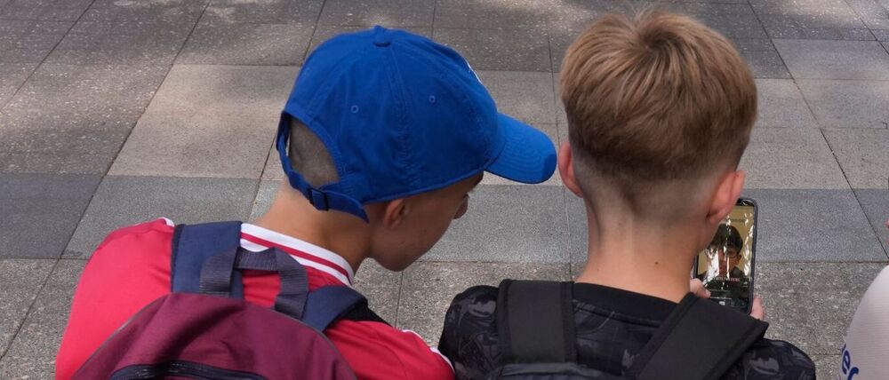 Kinder spielen auf ihren Smartphones.