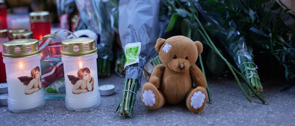 Kerzen und Stofftiere stehen in der Nähe der abgeriegelten Bar „Le Constellation“ in Crans-Montana.