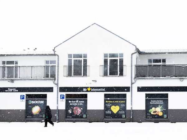 Eine Mitarbeiterin eines geschlossenen Supermarktes geht während eines Stromausfalls im Südwesten Berlins an der Filiale vorbei. Nach dem Brand einer Kabelbrücke ist im Südwesten Berlins für 50.000 Haushalte und 2.000 Gewerbebetriebe der Strom ausgefallen. +++ dpa-Bildfunk +++