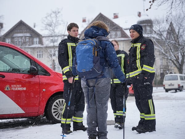 Mitglieder der freiwilligen Feuerwehr geben einer Passantin Auskunft an einem „Notruf Annahmepunkt“ am Mexikoplatz nach einem Stromausfall. Nach einem Brand an einer Kabelbrücke am Kraftwerk Lichterfelde kommt es durch den Stromausfall im Südwesten von Berlin zu Beeinträchtigungen. +++ dpa-Bildfunk +++