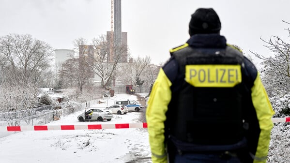 Ein Polizeibeamter steht an der Brandstelle am Teltowkanal. Nach dem Brand einer Kabelbrücke ist im Südwesten Berlins für 50.000 Haushalte und 2000 Gewerbebetriebe der Strom ausgefallen.