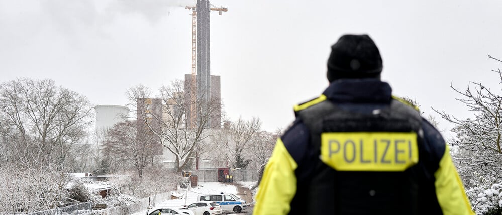 Ein Polizeibeamter steht an der Brandstelle am Teltowkanal. Nach dem Brand einer Kabelbrücke ist im Südwesten Berlins für 50.000 Haushalte und 2000 Gewerbebetriebe der Strom ausgefallen. 
