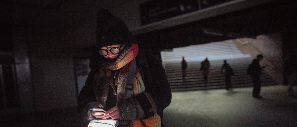 Die Berlinerin Bonnie geht mit Handylicht durch den Bahnhof Wannsee nach einem Stromausfall. 
