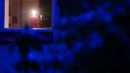 Eine Kerze steht während eines Stromausfalls im Südwesten Berlins in einem Fenster.