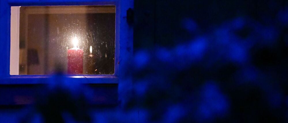 Eine Kerze steht während eines Stromausfalls im Südwesten Berlins in einem Fenster. 