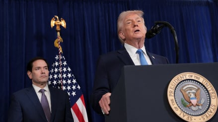 Donald Trump spricht am Mittag nach den Angriffen auf Venezuela, im Hintergrund sein Außenminister und Sicherheitsberater Marco Rubio.