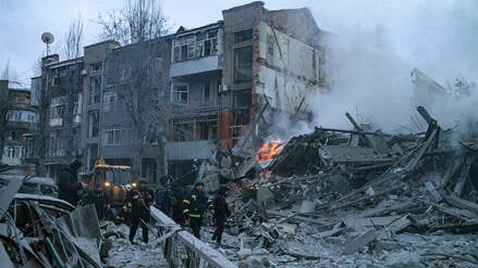 Rettungskräfte durchsuchen in Charkiw nach einem russischen Angriff Trümmer.