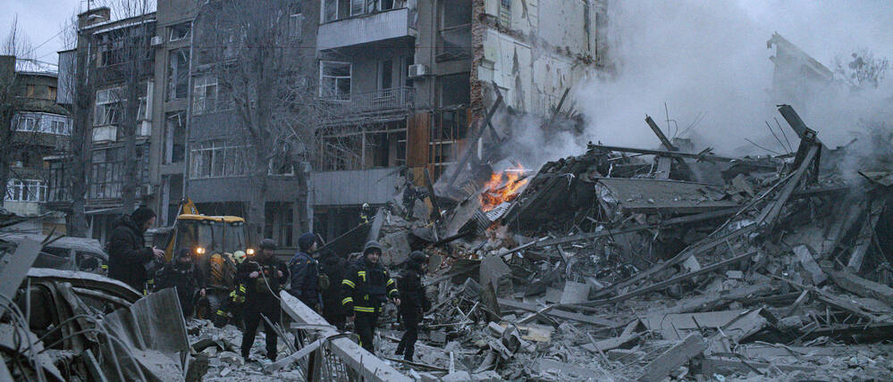 Rettungskräfte durchsuchen in Charkiw nach einem russischen Angriff Trümmer.