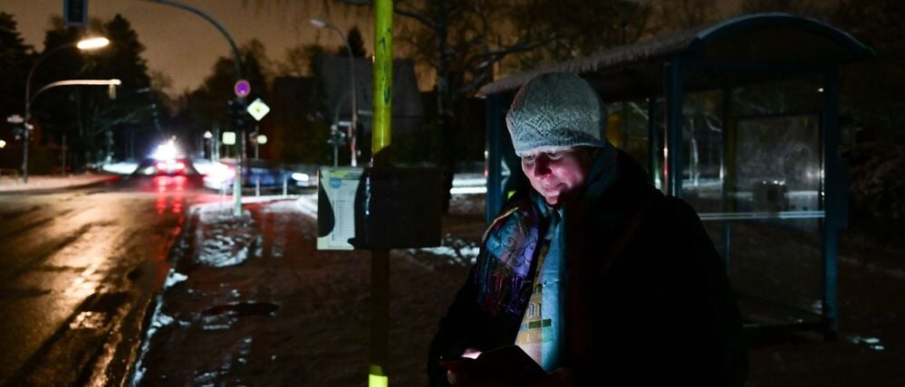 Edith wartet während eines Stromausfalls im Südwesten Berlins auf den Bus.