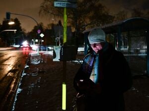 Edith wartet während eines Stromausfalls im Südwesten Berlins auf den Bus.