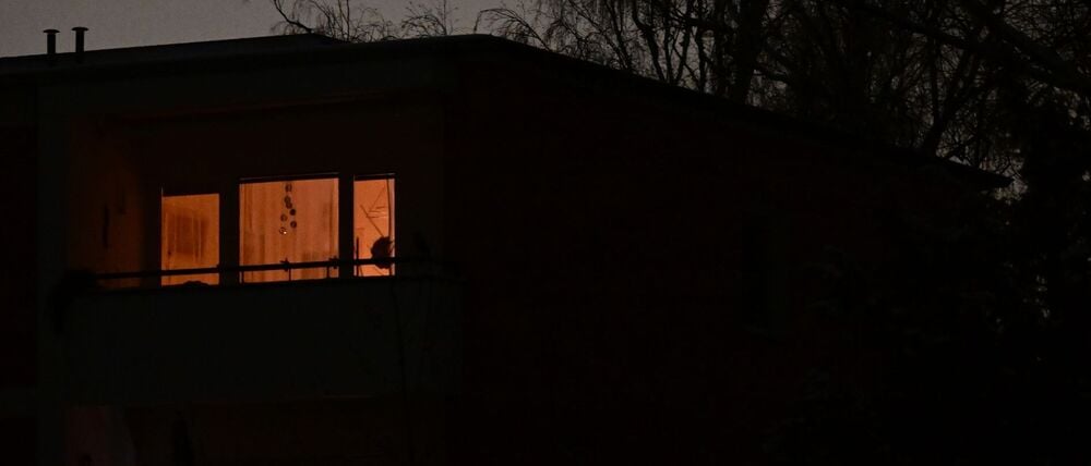 Zwei Fenster leuchten während eines Stromausfalls im Südwesten Berlins in einem Mehrfamilienhaus.