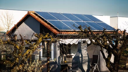 Solarpanele auf einem Dach eines Schrebergartenhauses.
