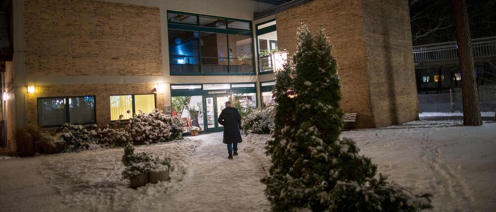 Eine ehrenamtliche Helferin geht zum Gemeindehaus der Emmaus-Gemeinde.