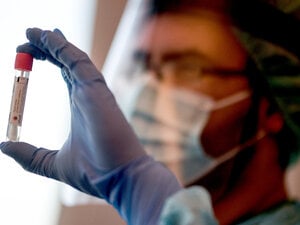 Ein Arzt hält in der Corona-Teststelle einen Abstrich für einen Coronavirus-Test.