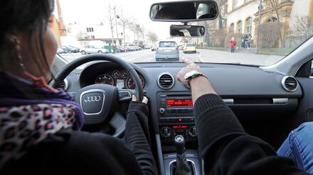 Eine 17-jährige Fahrschülerin und ihr Fahrlehrer sitzen in einem Fahrschulauto.