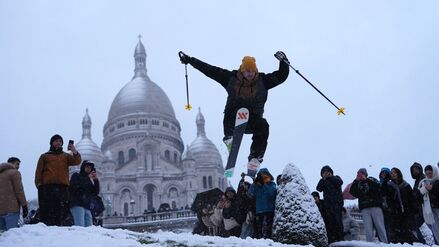 Im Pariser Viertel Montmartre: Ein Mann springt mit seinen Skiern den Hügel bei der Basilika Sacre-Coeur hinunter. 