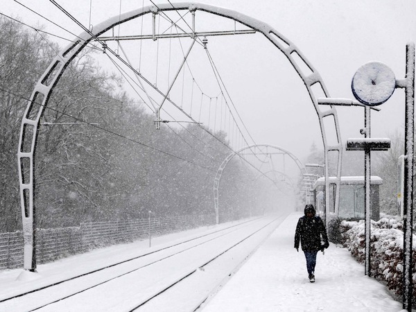 A train passenger walks on a snow-covered platform along a railway in Hollandsche Rading, The Netherlands on January 5, 2026 as train traffic is affected by the wintry weather. (Photo by Sander Koning / ANP / AFP) / Netherlands OUT
EU_Snow