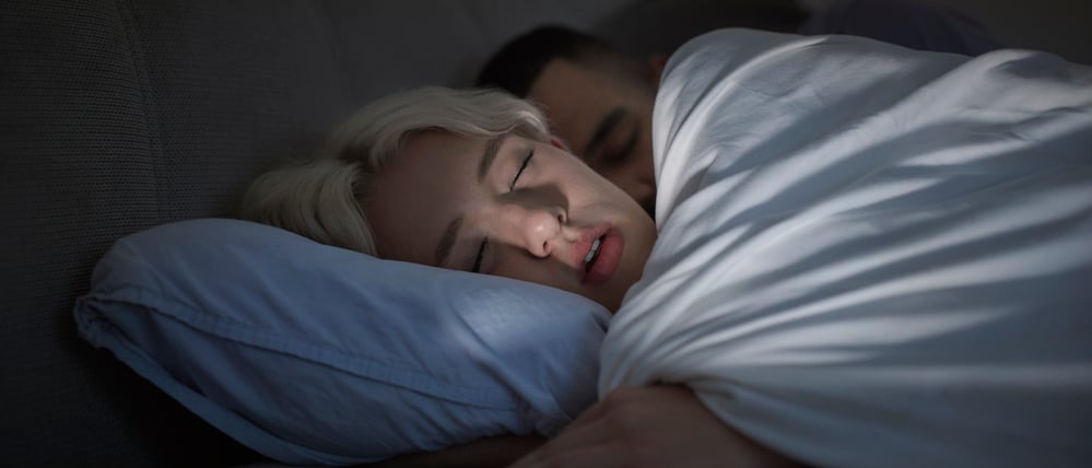 Ein junges Paar liegt im Bett (Symbolbild).