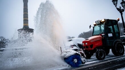Ein Schneeräumfahrzeug reinigt den Fahrradweg vor der Siegessäule am Großen Stern.