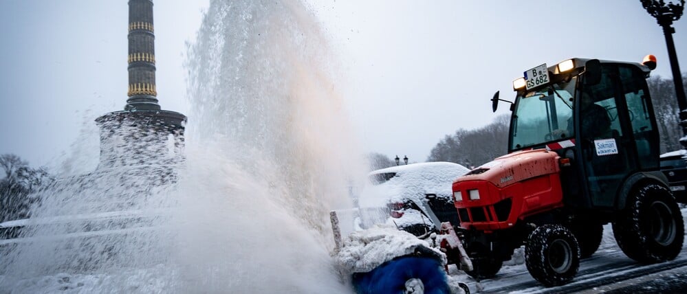 Ein Schneeräumfahrzeug reinigt den Fahrradweg vor der Siegessäule am Großen Stern.
