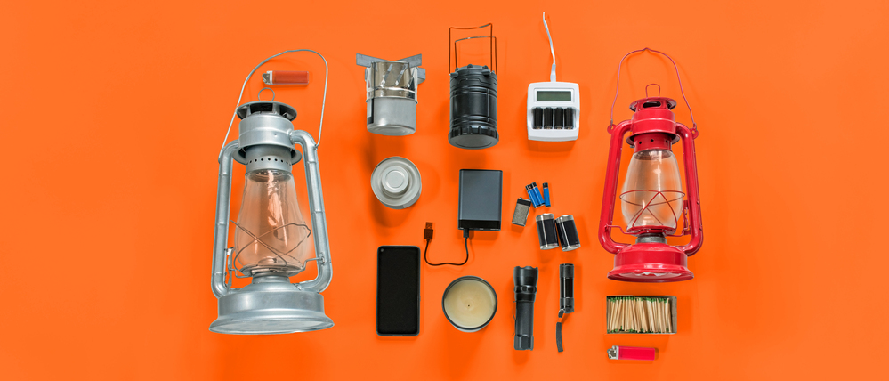 Überlebensausrüstung für den Fall eines Stromausfalls, einschließlich Petroleumlampen, Taschenlampen, Batterien, Ladegerät und externer Stromspeicher.