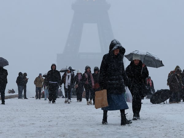 People walk in the snow-covered Trocadero square near the Eiffel Tower, as winter weather with snow and cold temperatures hits a large part of the country, in Paris, France, January 5, 2026. REUTERS/Gonzalo Fuentes