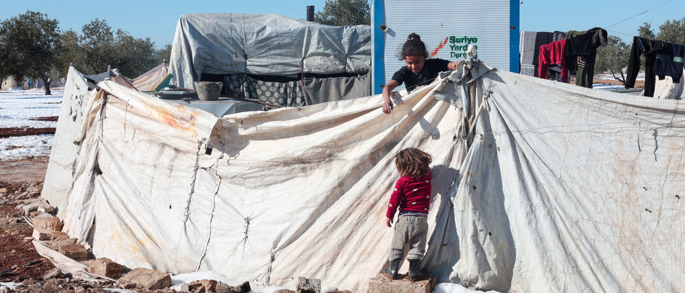 A girl helps her sister in front of their tents in the Aleppo countryside, after days of snowstorm that occurred in northern Syria, Aleppo, Syria, January 5, 2026. REUTERS/Mahmoud Hassano TPX IMAGES OF THE DAY