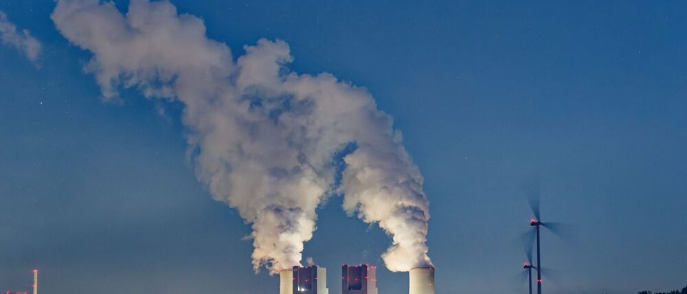 Kondensierter Wasserdampf steigt von den Kühltürmen des Braunkohlekraftwerkes Neurath auf. Das Kraftwerk stößt große Mengen Kohlendioxid aus. (Symbolbild)