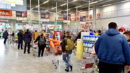 Lange Schlangen an den Kassen eines Baumarkts.